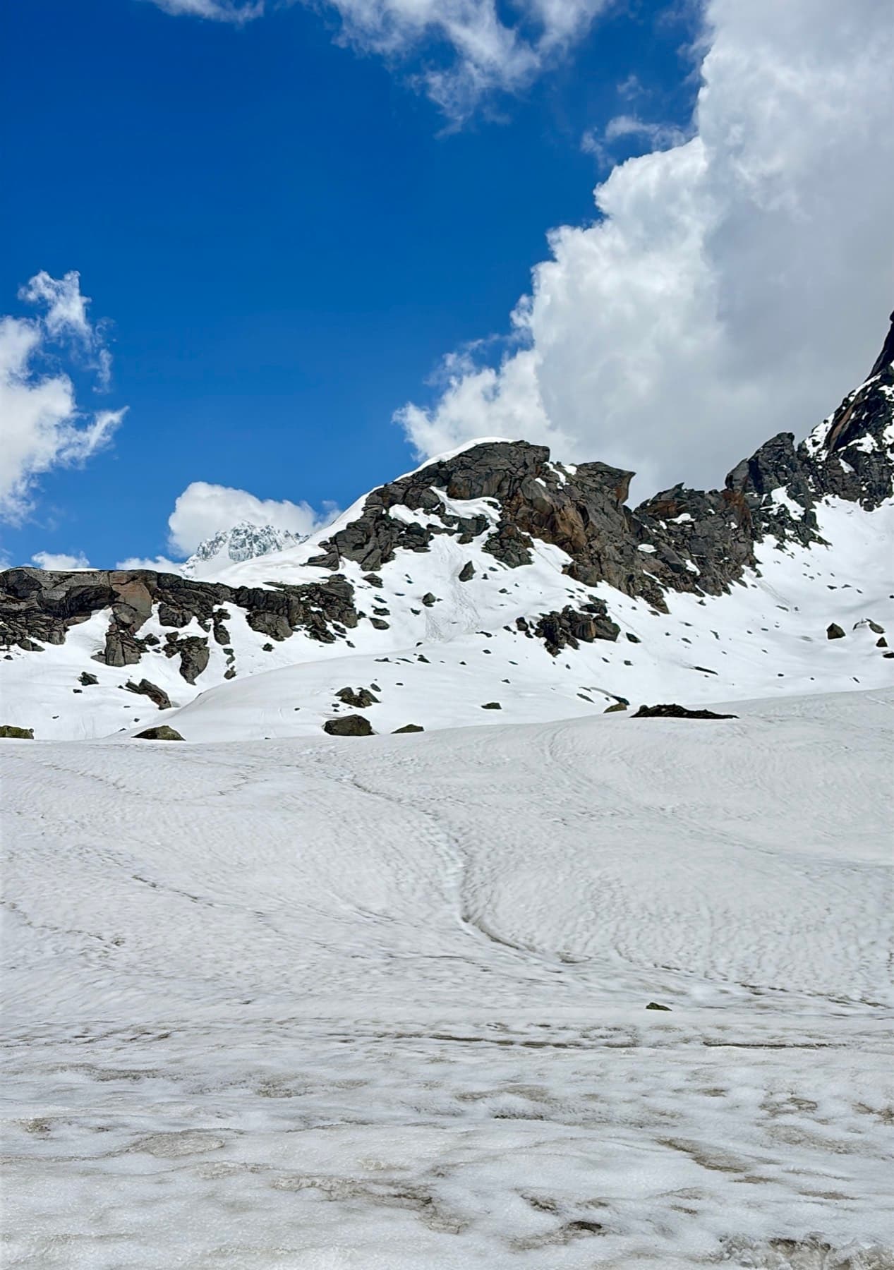 Snowfield below a rocky ridge on the way to Hampta Pass
